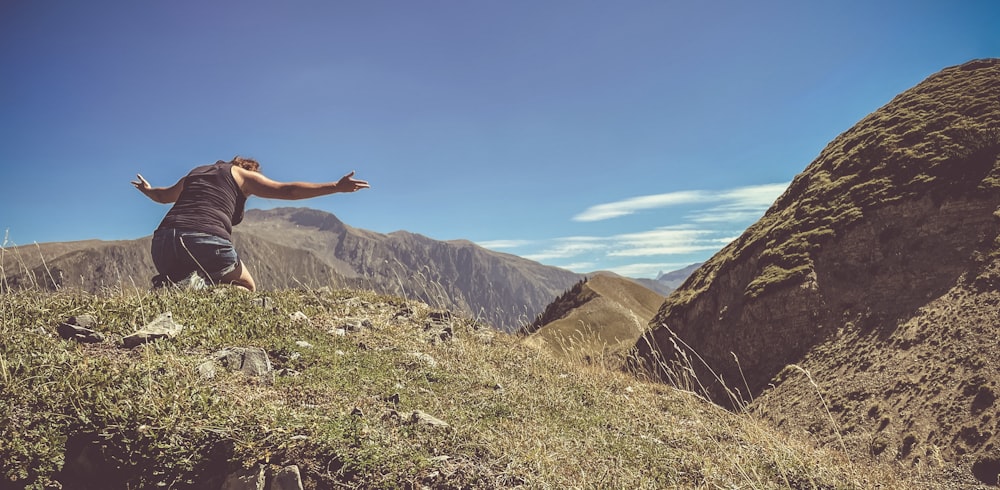 a man standing on top of a lush green hillside