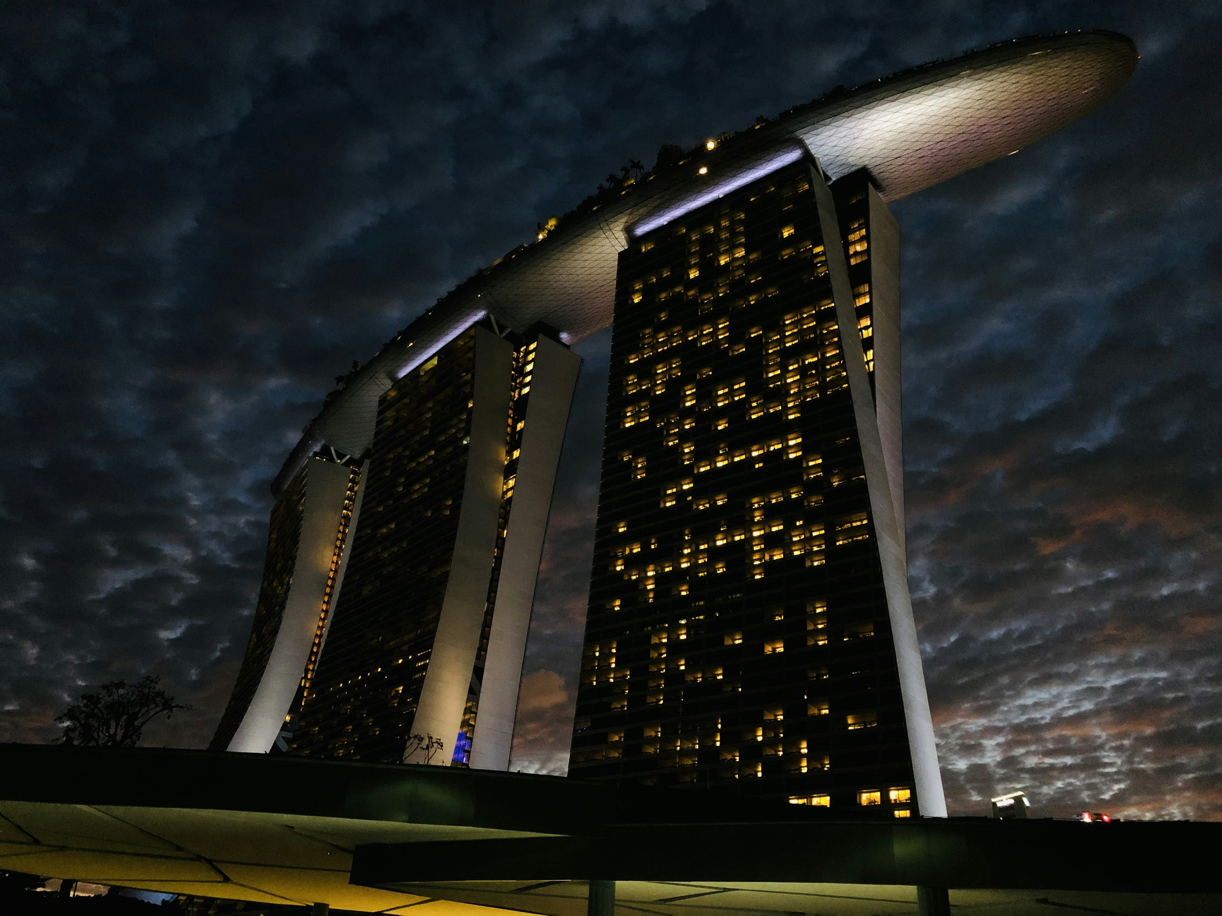 A very tall building sitting under a cloudy sky photo – Free Marina bay ...
