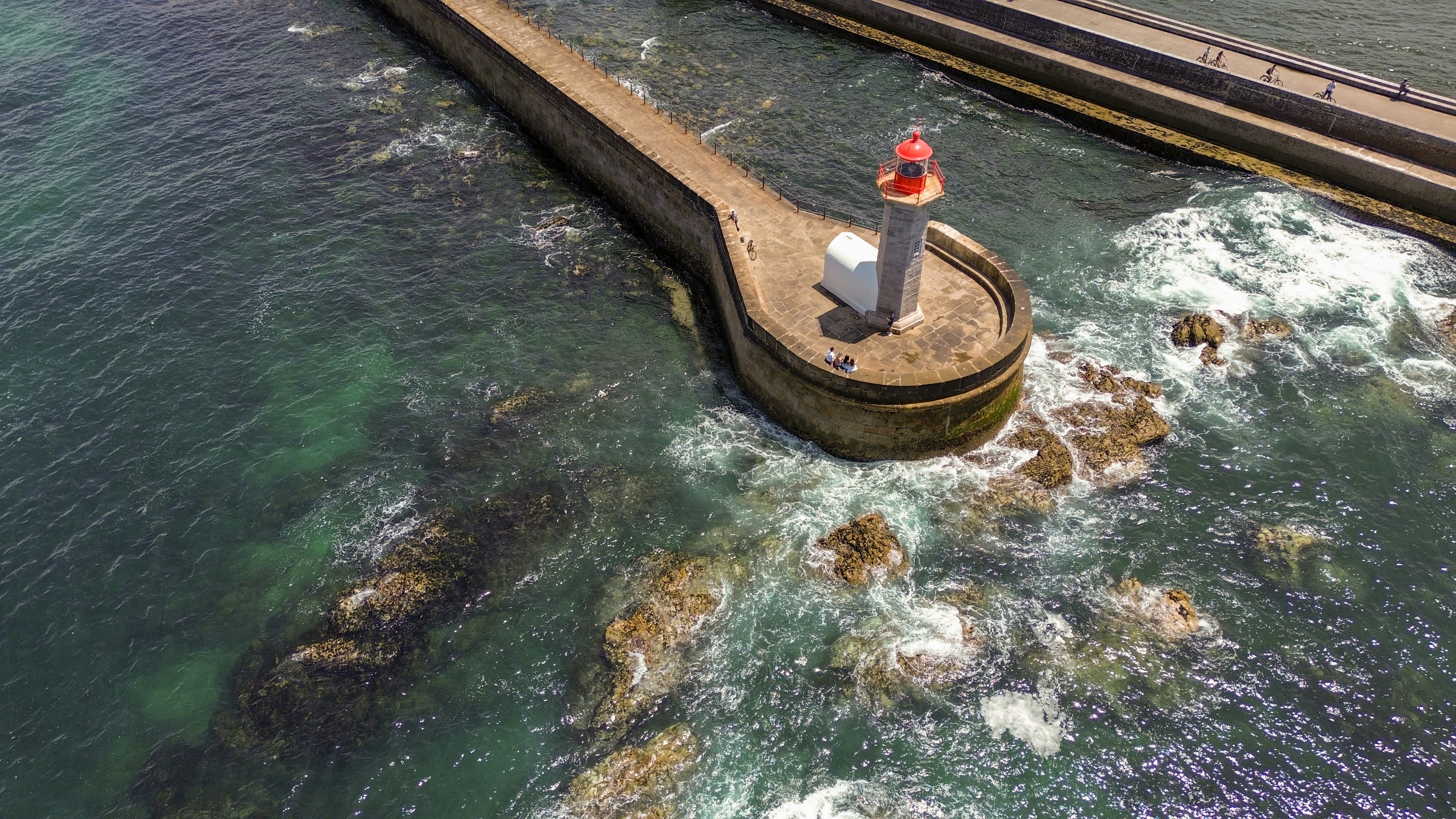 Ein Mann, der auf einem Pier neben dem Meer steht