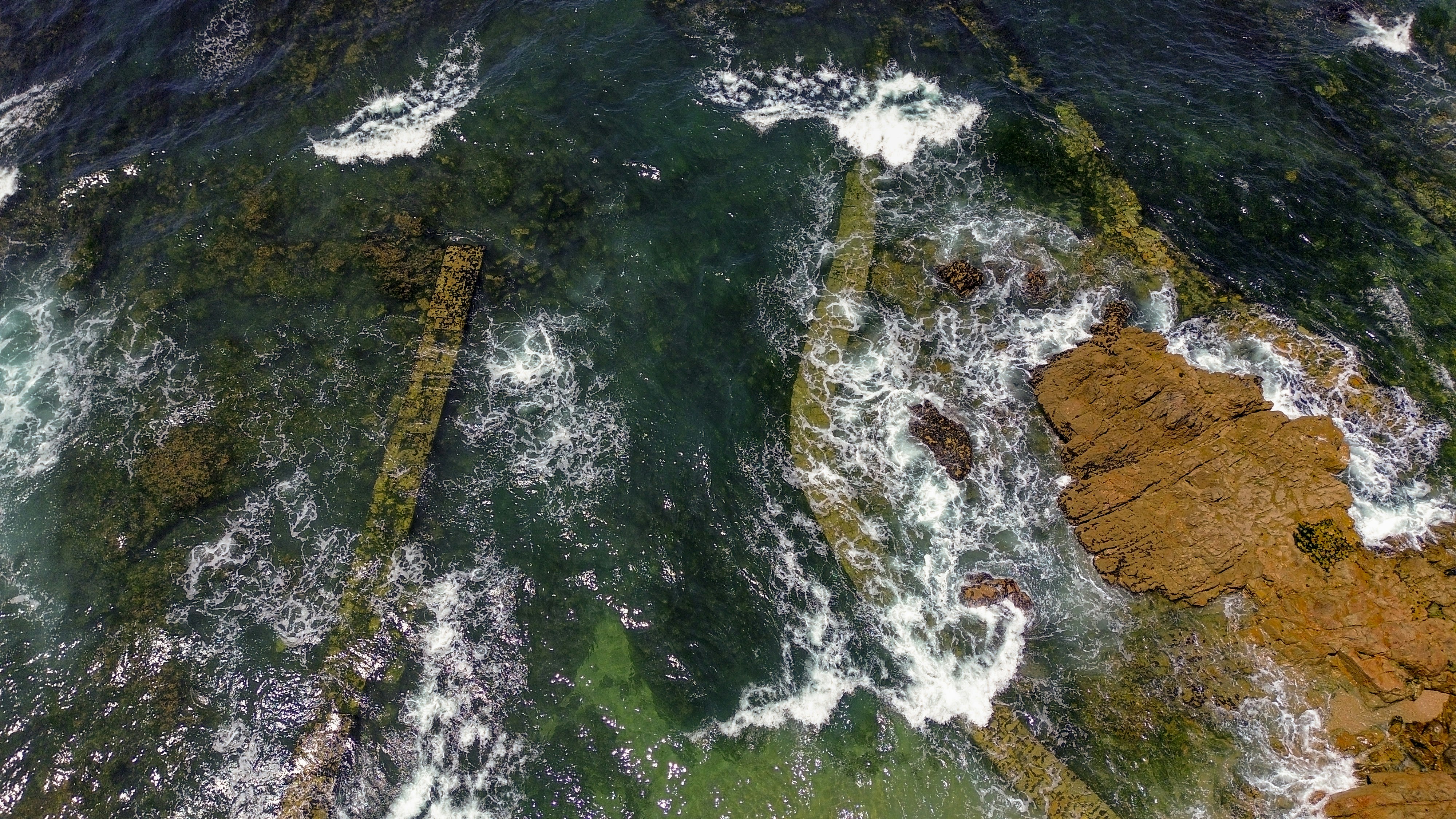 Luftaufnahme eines von Felsen umgebenen Gewässers