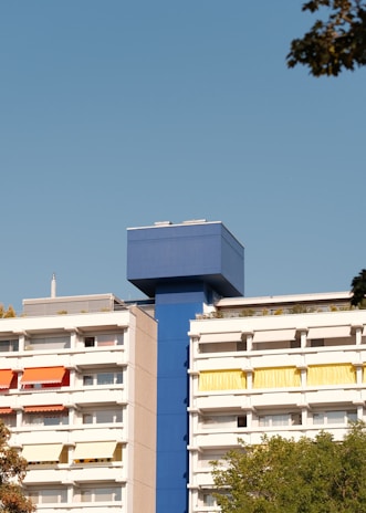 A freshly painted modern residential building with vibrant colors under a clear blue sky.
