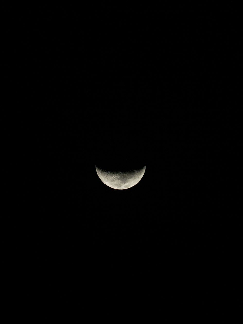 the moon is seen through the dark night sky