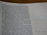 A close-up view of a page from a Bible open to the book of Ezekiel, with text visible and partially focused on verses discussing divine warnings and moral guidance. The page appears to be on a desk, and part of the page is slightly out of focus.