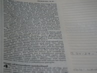 A person writing notes while reading a Bible in a cozy nook.