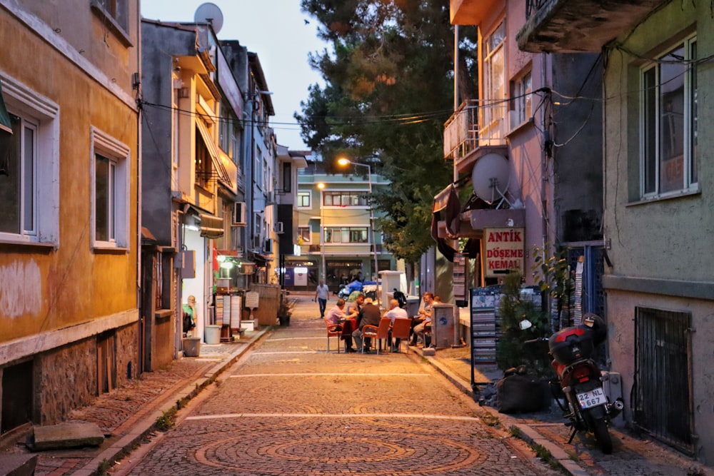 a group of people walking down a street next to tall buildings