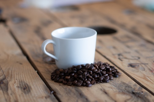 a cup of coffee sitting on top of a wooden table