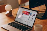A cozy desk setup with a laptop displaying social media icons.