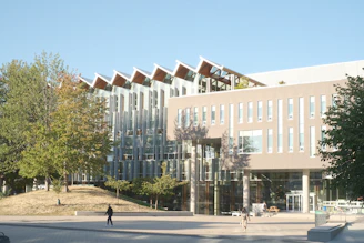 Modern university building entrance with green and white accents reflecting institutional colors.