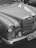 A classic car featuring a shiny chrome grill and headlight details, with smooth, curved lines and a distinct emblem on the hood.