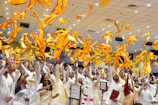 Children joyfully singing in a bright church hall decorated with blue and gold banners.