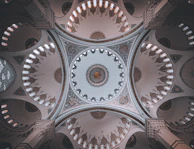 Close-up of intricate Islamic patterns on a mosque wall with soft lighting.
