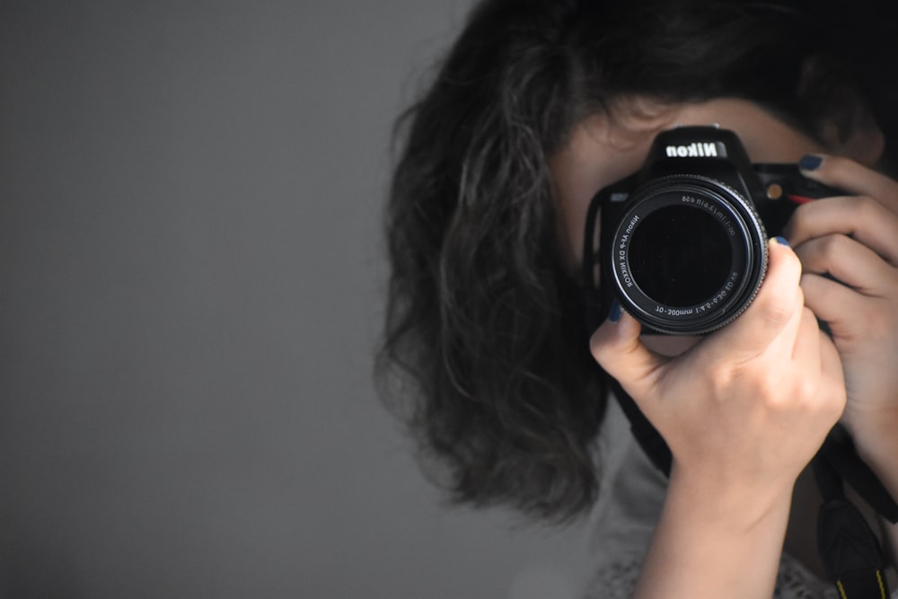 a woman holding a camera up to her face