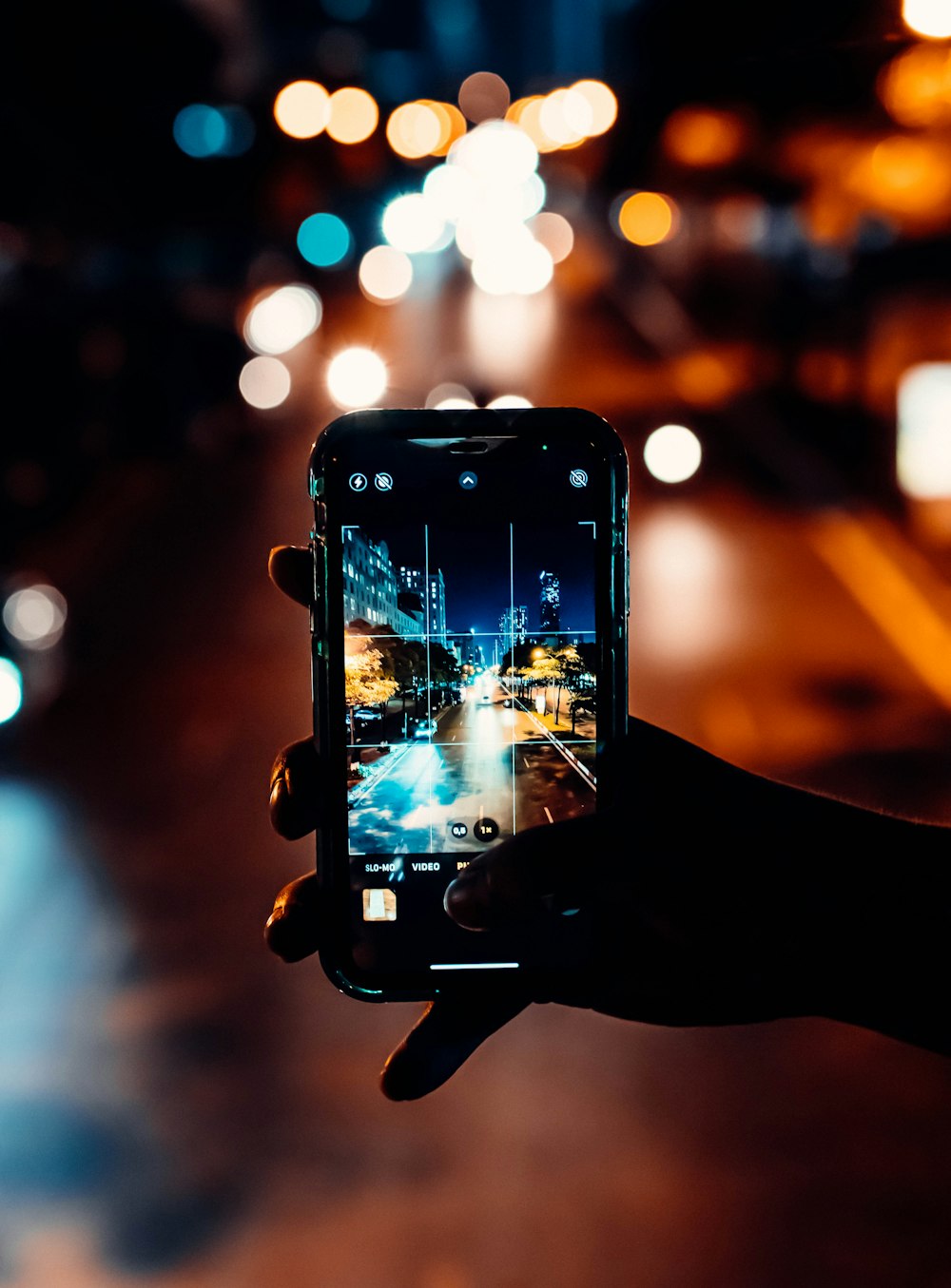 una persona che scatta una foto di una strada della città di notte