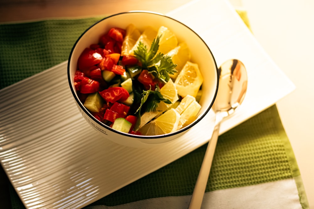 a bowl of fruit and vegetables on a place mat