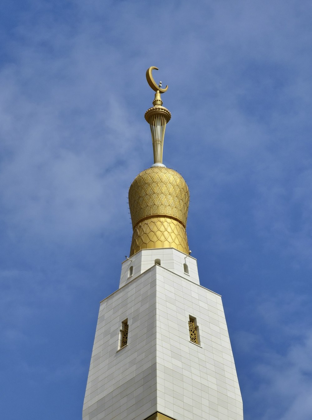 a tall white tower with a gold top