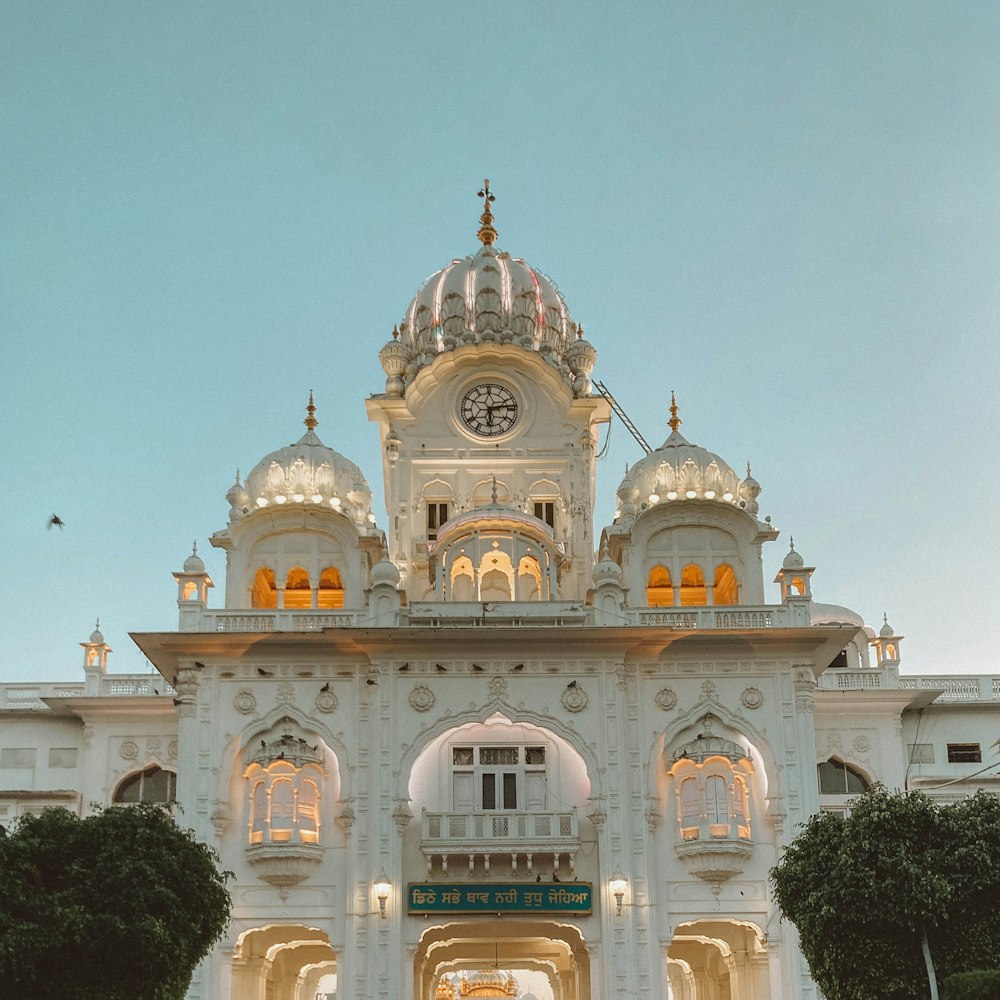 a large white building with a clock on the top of it