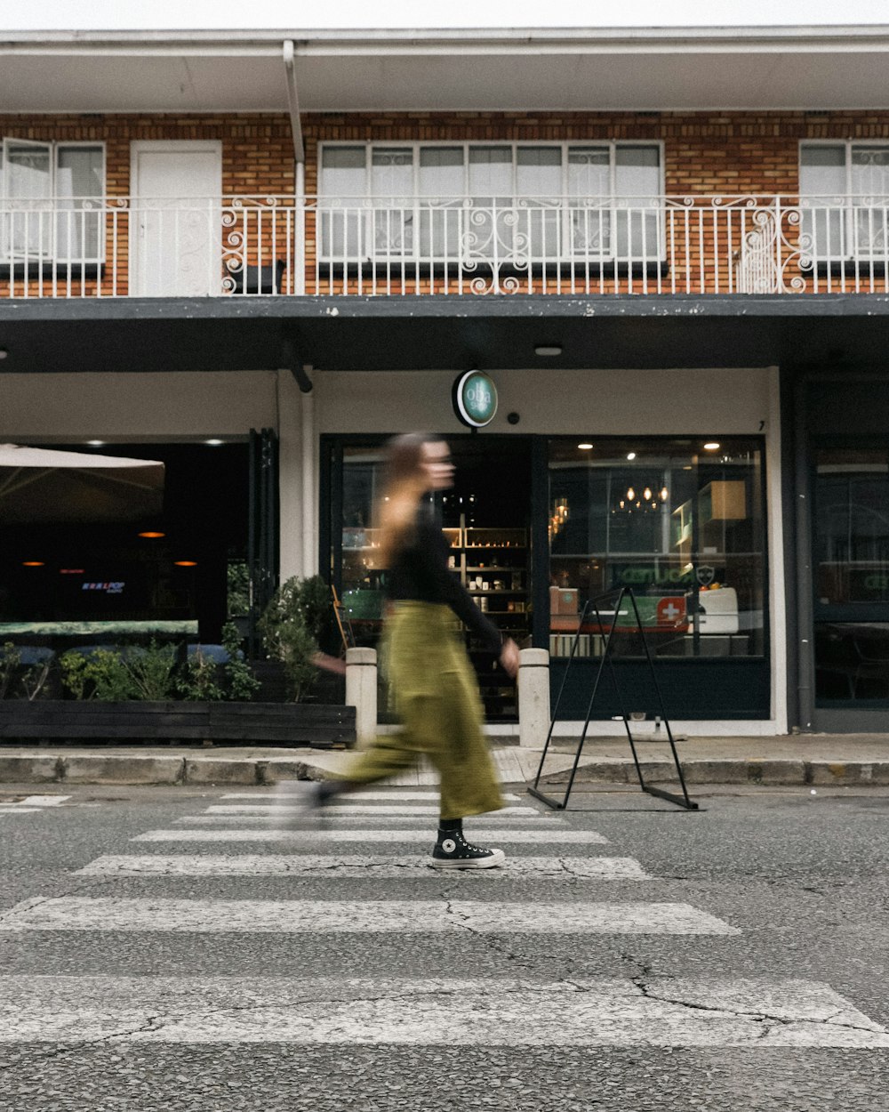 a person crossing a street in front of a building