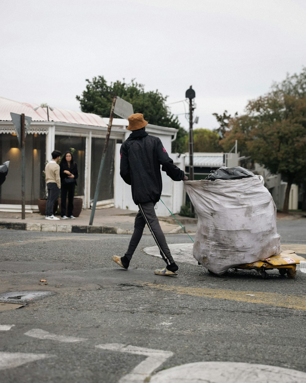 a man pushing a cart with a large bag on it