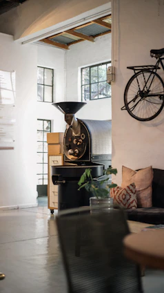 A cozy corner of the Brisa Café roasting room with pastel-colored walls and bags of freshly roasted coffee beans.