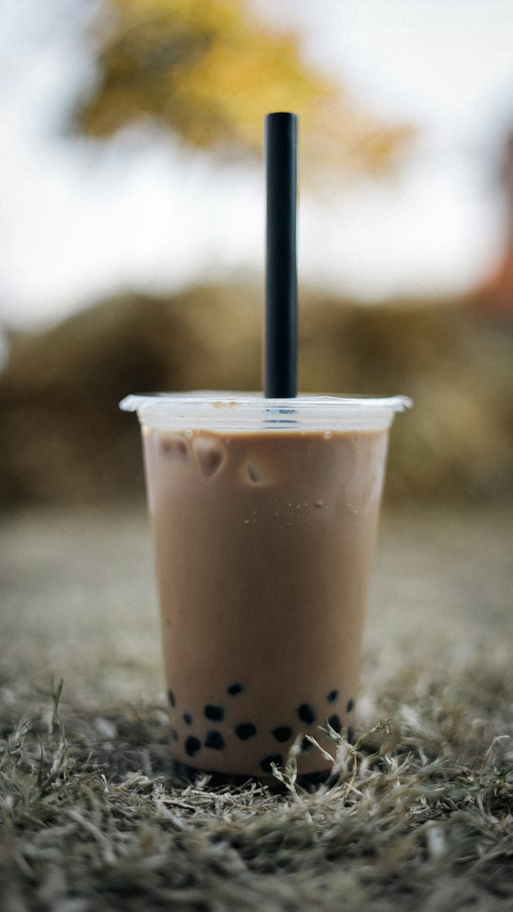 un vaso de plástico con una pajita negra que sobresale de él