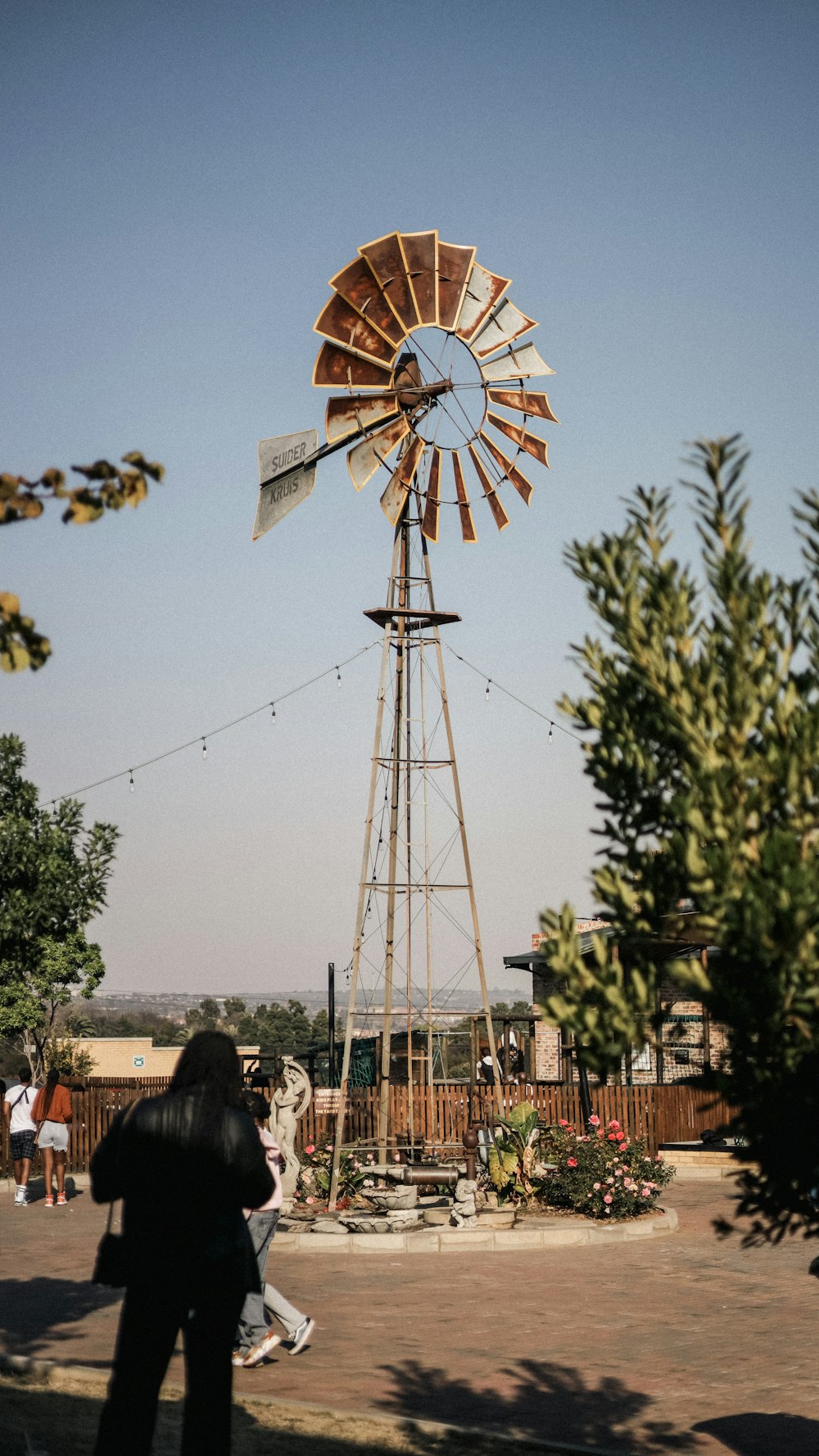 a woman is standing in front of a windmill