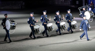A focused drumline group practicing together in matching uniforms.