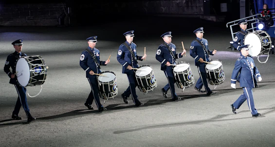 A focused drumline group practicing together in matching uniforms.