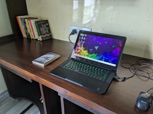 A modern study desk with a laptop displaying complex neural network graphics.