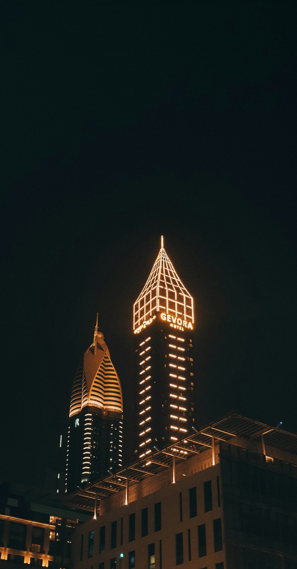 a tall building with a lit up clock on it's side