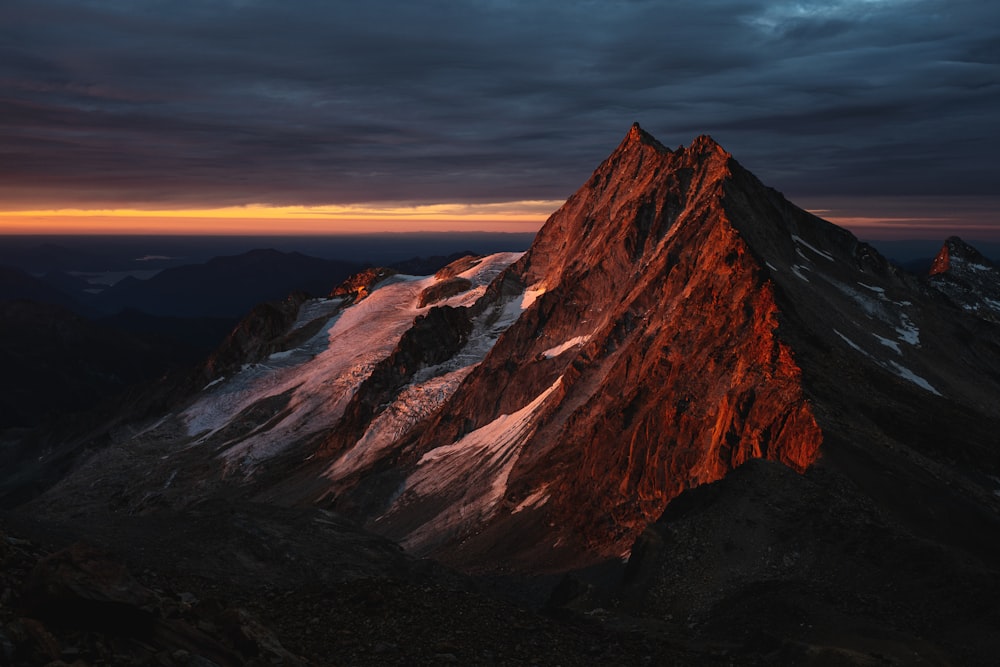 Ein sehr hoher Berg mit einem Sonnenuntergang im Hintergrund