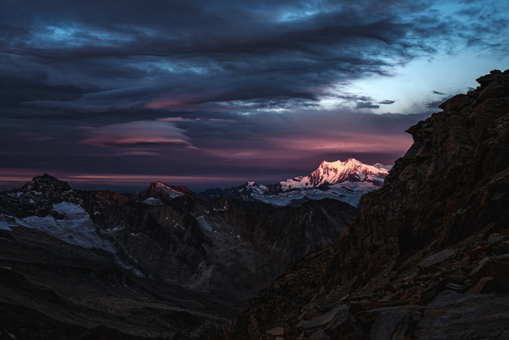 Blick auf eine Bergkette mit einem Sonnenuntergang im Hintergrund