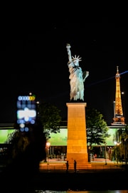 the statue of liberty is lit up at night
