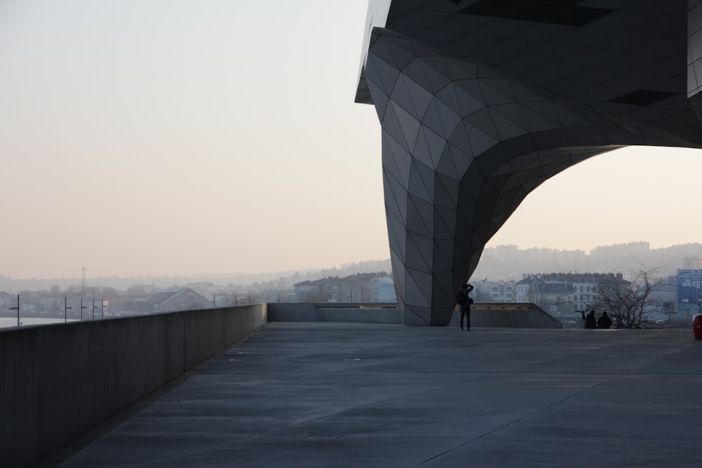 a person standing on a walkway near a building