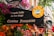 A lively French restaurant storefront adorned with colorful flowers and quaint signage. The sign advertises traditional French cuisine, specifically fondue, with a whimsical illustration of a fondue pot. The exterior is vibrant with hanging lights and various decorative elements.