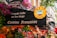 A lively French restaurant storefront adorned with colorful flowers and quaint signage. The sign advertises traditional French cuisine, specifically fondue, with a whimsical illustration of a fondue pot. The exterior is vibrant with hanging lights and various decorative elements.