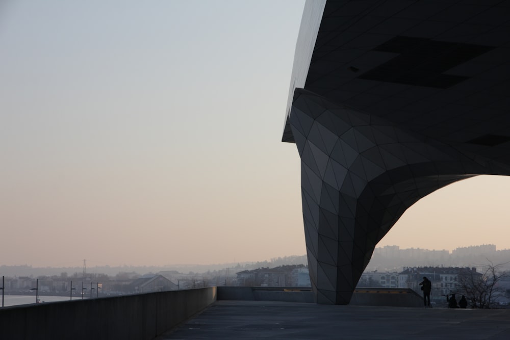 eine Person, die auf einer Brücke mit einer Stadt im Hintergrund steht