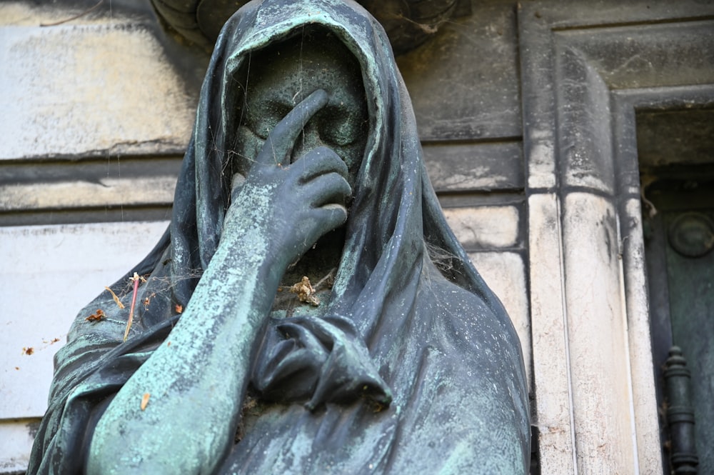 a statue of a woman covering her face with her hands