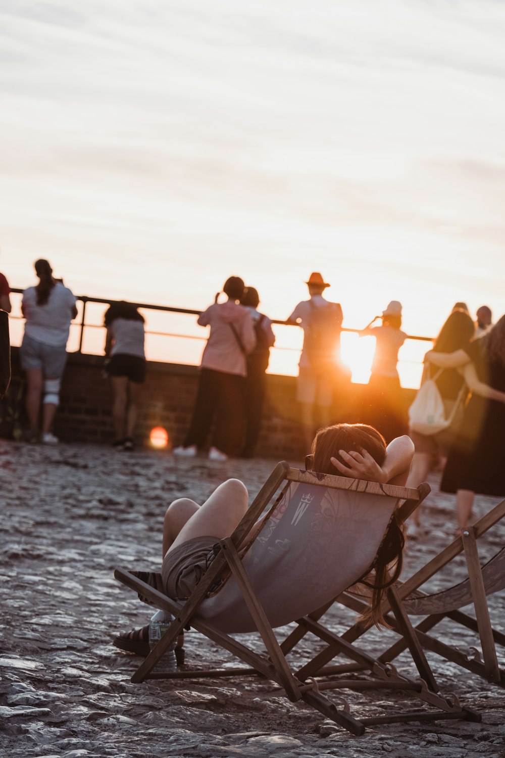 a group of people standing and sitting around a beach