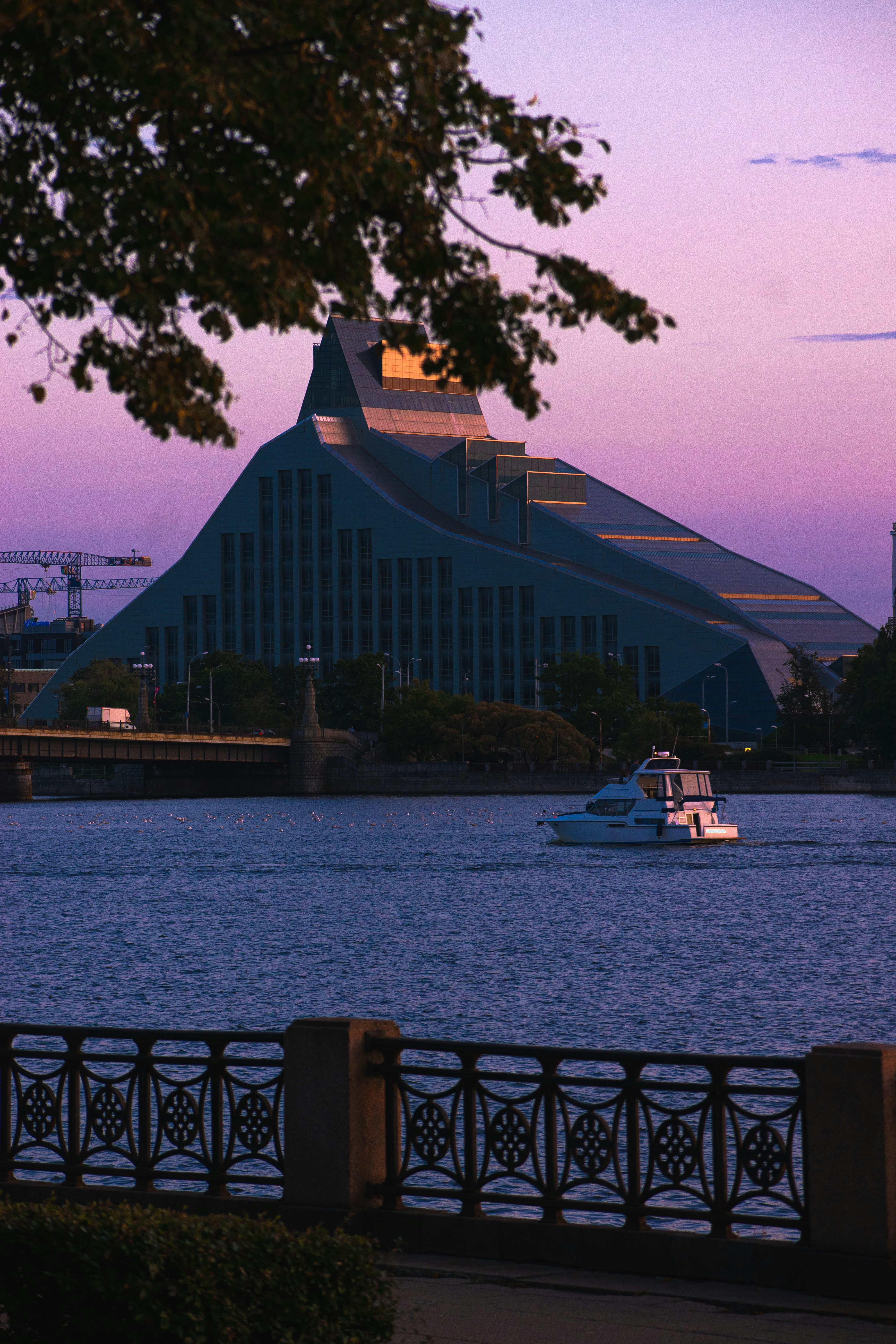 a boat traveling down a river next to a tall building