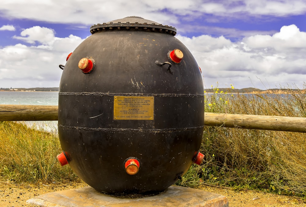 a large black object sitting on top of a cement slab