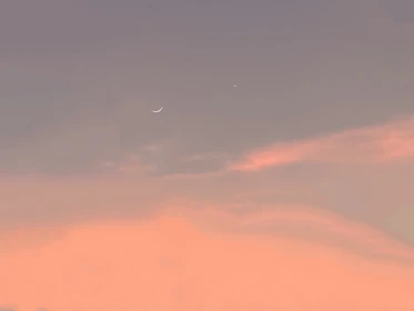 soft stars twinkling over a dimly lit room with a crescent moon glowing gently outside the window.