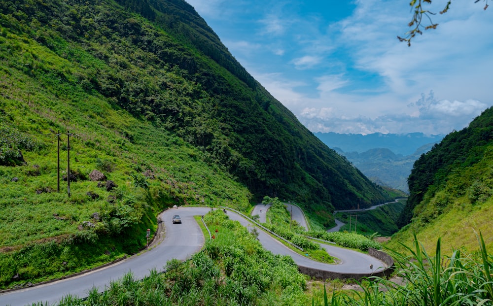 um carro dirigindo por uma estrada sinuosa de montanha