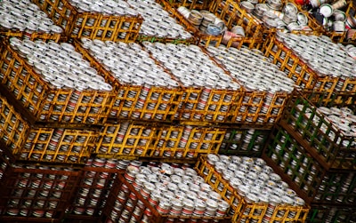 Stacks of neatly arranged beer cartons on pallets in a modern warehouse.
