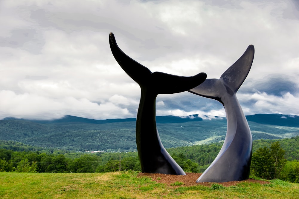 a sculpture of a whale tail on top of a hill