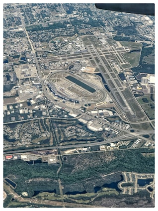 A futuristic aerial view of the proposed Great London Airport sprawling across the Thames Estuary with multiple runways and connected high-speed rail.