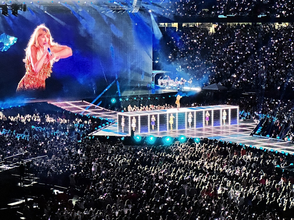 a crowd of people watching a woman on a stage