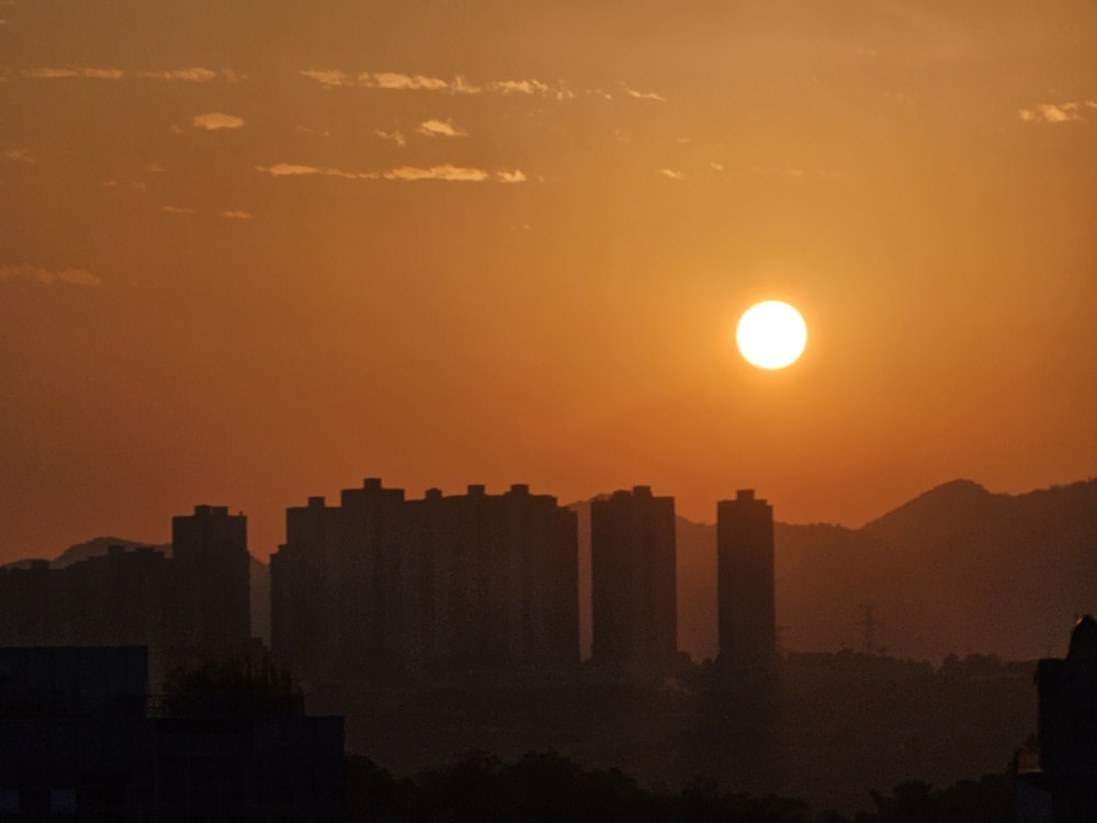 O sol está se pondo sobre uma cidade com edifícios altos