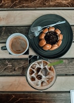 A group of friends enjoying coffee and desserts around a rustic wooden table.