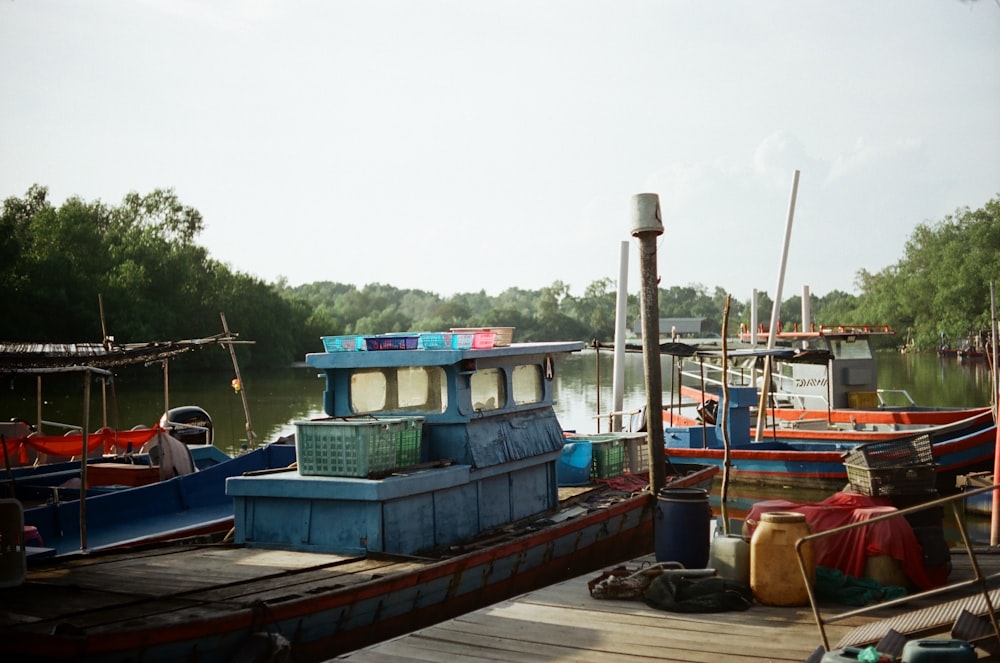 several boats are docked at a dock on the water