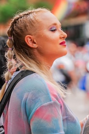 Vibrant outdoor portrait of a transgender American standing in a sunlit urban setting.